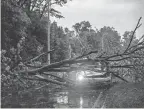  ?? KENDALL WARNER/THE VIRGINIAN-PILOT VIA AP ?? A vehicle is crushed by a fallen tree Sunday in Virginia Beach, Va., as a result of a storm that ripped through the area.