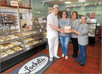  ?? GENE WALSH — DIGITAL FIRST MEDIA ?? Lochel’s Bakery owners and staff members Rob Lochel, left, Kathleen Lochel, Stacey Hill and Lisa Neimann gather together at the bakery, which was recently named the Sweetest Bakery in America.