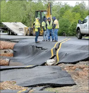  ?? NWA Democrat-Gazette/DAVID GOTTSCHALK ?? Washington County Road Department personnel survey damage Monday on County Road 859 in Wheeler. Heavy rains caused flooding on area creeks, including Clear Creek.