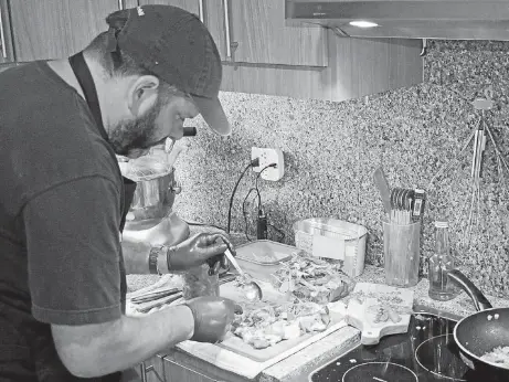  ?? FOTOS JULIA VÉLEZ ?? David Scheitlin prepara una milanesa con queso, tocino y huevos, un plato típico argentino.