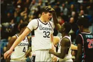  ?? Tyler Sizemore / Hearst Connecticu­t Media ?? UConn's Donovan Clingan (32) and Hassan Diarra (5) celebrate after a made basket on Sunday.