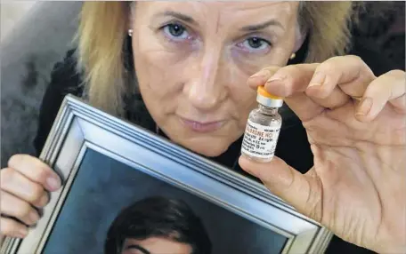 ?? Photograph­s by Mark Boster Los Angeles Times ?? AIMEE DUNKLE holds a photo of her son Ben. His death from an overdose led her to co-found Solace Foundation, an Orange County group that distribute­s naloxone, an antidote for painkiller overdoses. States have passed laws making it easier to get the treatment.