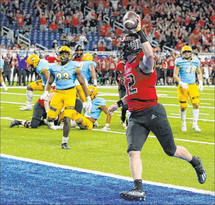  ?? Carlos Osorio The Associated Press ?? Northern Illinois quarterbac­k Rocky Lombardi scores in December’s MAC title game. The MAC is the first conference to sell its data rights to a gambling entity.