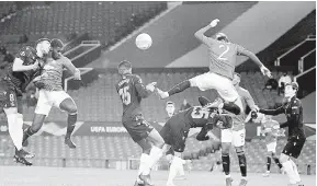  ?? — Gambar AFP ?? CARI RUANG: Axel Tuanzebe (dua kiri) menanduk bola pada perlawanan Liga Europa di antara Manchester United dan Real Sociedad di Old Trafford di Manchester, England, kelmarin.