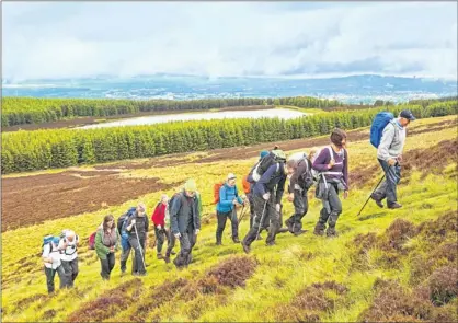  ??  ?? WALKING TALL: A group of ramblers heading for the summit near Bonaly Reservoir in the Pentland Hills. Picture: Phil Seal/Alamy