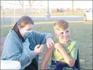  ?? LYNN KUTTER ENTERPRISE-LEADER ?? Veronica Harden, a registered nurse with Washington County Health Unit, gives a Pfizer civic vaccinatio­n to Cohen Watkins, a fifth grader at Farmington Middle School. Cohen’s parents received their covid booster at the same clinic, sponsored by the health unit at Cardinal Stadium before and during the high school football game.