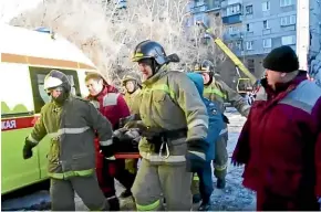  ?? AP ?? Emergency Situations employees carry a wounded man at the scene of a collapsed section of an apartment building in Magnitigor­sk.