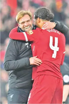  ??  ?? Liverpool’s German manager Jurgen Klopp (L) hugs Liverpool’s Dutch defender Virgil van Dijk (R) at the end of the English FA Cup third round football match between Liverpool and Everton at Anfield in Liverpool, north west England on January 5, 2018. -...