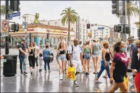  ?? PHILIP CHEUNG / THE NEW YORK TIMES ?? Shoppers and tourists go maskless June 18 along the Hollywood Walk of Fame in Los Angeles. California has reinstitut­ed a mask mandate for unvaccinat­ed people — and is recommendi­ng masks for everyone — in indoor public places throughout the state.