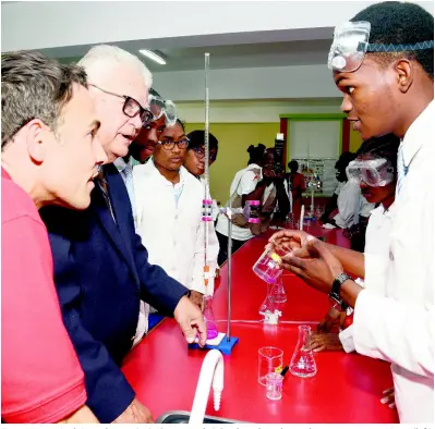  ?? IAN ALLEN/PHOTOGRAPH­ER ?? Tavar Harriot (right), student at St Catherine High School, explains basic chemistry to Justin Morin (left), chief executive officer of Digicel Jamaica, and Karl Samuda (second left), minister without portfolio, Ministry of Education, Youth and Informatio­n, following the opening ceremony of the school’s science lab, renovated by Digicel Foundation, on Wednesday.