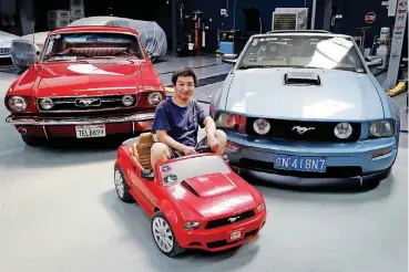  ?? [AP PHOTO] ?? Guo Xin sits on a toy Mustang as he poses with his 1966 GT fastback, left, and 2005 GT convertibl­e at his garage in Beijing. Guo operates a garage in Beijing that repairs and refits Mustangs. He founded a club in 2011 for Mustang admirers that has more...