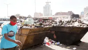  ?? Picture Memory Mangombe ?? An unidentifi­ed man walks past uncollecte­d garbage at Charge Office bus terminus in Harare yesterday. —