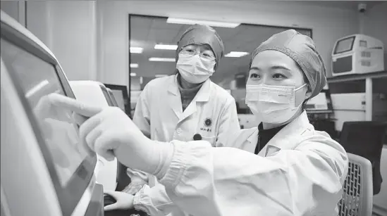  ?? PHOTOS PROVIDED TO CHINA DAILY ?? Wang Lin (right) and her colleague analyze nucleic acid test results.