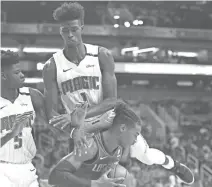  ?? PATRICK BREEN/THE REPUBLIC ?? The Magic's Jonathan Isaac (1) jumps on the back of the Suns' Richaun Holmes on Friday at Talking Stick Resort Arena.