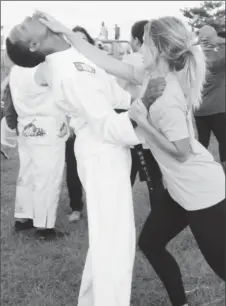  ??  ?? A participan­t practicing what she learned on one of the police force instructor­s