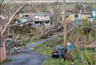  ?? AP PHOTO GERALD HERBERT ?? Jonathan Aponte walks with a gas can up the road to his home in the aftermath of Hurricane Maria, in Yabucoa, Puerto Rico, Tuesday.