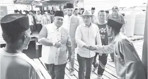  ??  ?? RONALD bersalaman dengan penduduk kampung.