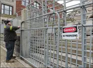  ?? DANA JENSEN/THE DAY ?? Anthony Greco, with New London Public Works, secures fencing with zip ties on Feb. 2 around the demolition site of the former First Congregati­onal Church in New London. The church collapsed on Jan. 25, and public works was preparing to open State Street for the first time since the collapse.