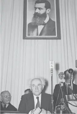  ?? (Frank Scherschel/GPO/Reuters) ?? DAVID BEN-Gurion sits under a portrait of Theodor Herzl, before the reading of Israel’s Declaratio­n of Independen­ce in Tel Aviv on May 14, 1948.