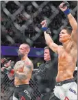  ?? David Dermer ?? The Associated Press Former profession­al wrestling star Phil “CM Punk” Brooks claps as Mickey Gall has his arm raised after their welterweig­ht bout won by Gall at UFC 203 on Sept. 10 in Cleveland.