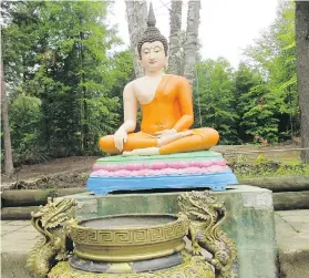  ??  ?? The statue of the Buddha sitting beneath a large tree depicts the moment when he attains enlightenm­ent. It is the most revered statue on the temple grounds.