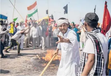  ?? ALTAF QADRI/AP ?? Protest hits milestone: A farmer shouts slogans as a mock corpse representi­ng India Prime Minister Narendra Modi burns Saturday along the near New Delhi. The farmers blocked a major highway to mark 100 days of protest against agricultur­al laws they say will devastate their income. Modi says the laws are necessary to modernize agricultur­e.