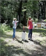  ??  ?? Natalie Hertzog and SaraAnn Harbonic practicing archery.