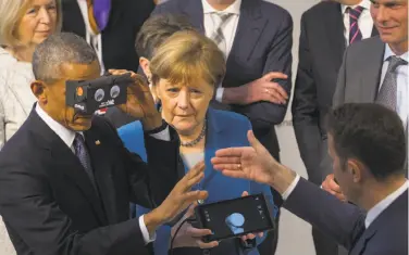  ?? Stephen Crowley / New York Times ?? President Obama and German Chancellor Angela Merkel try virtual reality goggles at a trade fair.