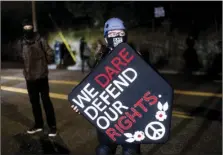  ?? PHOTO/NOAH BERGER
AP ?? Stacy Kendra Williams holds a shield while facing off against police at the Penumbra Kelly Building on Thursday, in Portland, Ore. This weekend Portland will mark 100 consecutiv­e days of protests over the May 25 police killing of George Floyd.