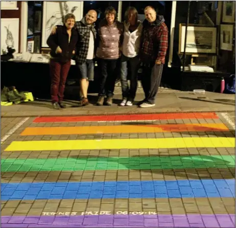  ??  ?? Chasing rainbows: Locals pose with the temporary crossing which was trialled in Totnes for gay pride week