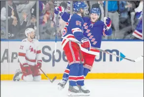  ?? John Minchillo The Associated Press ?? New York Rangers defenseman Adam Fox, right, celebrates with defenseman Ryan Lindgren (55) after scoring against the Carolina Hurricanes in the first period of Game 4 of their second-round playoff series Tuesday. The Rangers evened the series at 2-2.