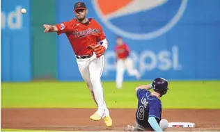  ?? SUE OGROCKI/ASSOCIATED PRESS ?? Cleveland Guardians right fielder Gabriel Arias, left, forces out the Tampa Bay Rays’ Brandon Lowe (8) at second base and completes the throw to first base for a double play Saturday in Cleveland.