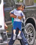  ?? MATT YORK/ASSOCIATED PRESS ?? A child is carried from a van to a Lutheran Immigratio­n and Refugee Service office in Phoenix on Thursday as the government rushed to reunite immigrant families separated at the border.