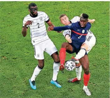  ?? FOTO: CHRISTIAN CHARISIUS/DPA ?? Antonio Rüdiger (l.) und Robin Gosens (r.) nehmen Frankreich­s Paul Pogba in die Zange.