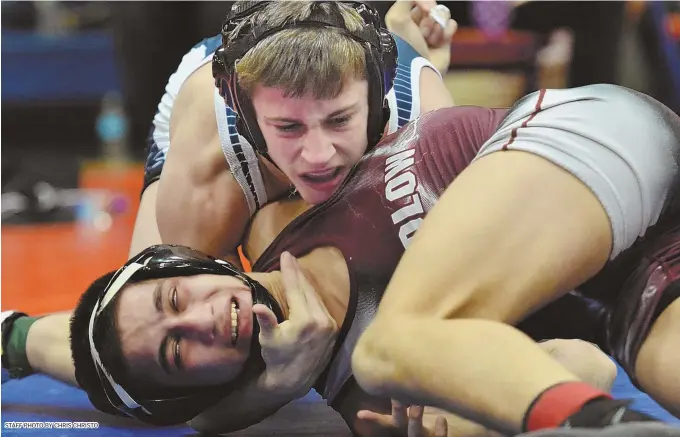  ?? STAFF PHOTO BY CHRIS CHRISTO ?? LOCKING UP A TITLE: Ryan Garlitz of St. John’s Prep (top) has control of Ludlow’s Cesar Alvan during the Eagles wrestler’s 9-3 decision victory to capture the 132-pound title at the Division 1 championsh­ips yesterday at Newton South High School.