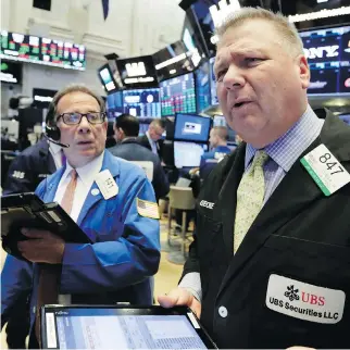  ?? AP PHOTO/RICHARD DREW ?? TraDers Sal Suarino, left, anD George Ettinger work on the floor of the New York StoCk ExChange in May. StoCks are off to a mostly lower start, anD a market CorreCtion CoulD Be on its way.