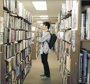  ??  ?? TEPPEI HIROSE, a graduate student at UC Irvine, drove two hours to find a scholarly book on philosophy. The store’s shelves are stocked with classic lit, biographie­s, sci-fi and more.