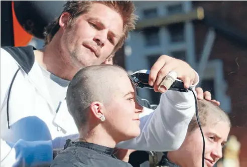  ?? Photo: DEAN KOZANIC/FAIRFAX NZ ?? Clipping concentrat­ion: All Blacks captain Richiemcca­wshaves Emily-rose Dunn’s head at Lincoln University in a cancer-fundraisin­g event.