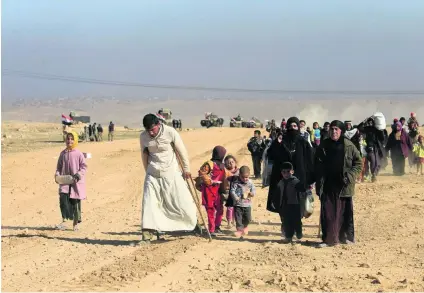  ?? Alaa Al Marjani / Reuters ?? Families flee their homes as Iraqi forces battle ISIL in the district of Maamoun in western Mosul.