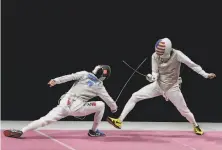  ?? Hassan Ammar / Associated Press ?? Alexander Massialas (right) duels with Tomohiro Shimamura of Japan in the men’s foil team bronze medal match.