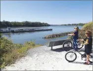  ?? Flip Putthoff/NWA Democrat-Gazette ?? Young Katy Trail riders watch barges on Oct. 9 being pushed upstream on the Missouri River.