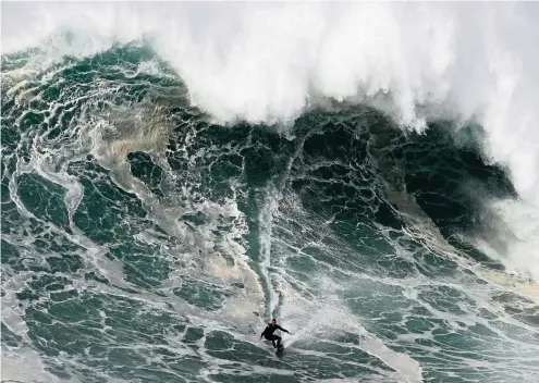  ?? FOTO: ARMANDO FRANCA / DPA ?? Wenn solch eine enorme Wand aus Wasser auf einen zukommt, sucht man normalerwe­ise das Weite. Mittlerwei­le gilt es aber als Extremspor­t und sorgt für die ganz besondere Action, Riesenwell­en wie diese hier zum Surfen zu nutzen.