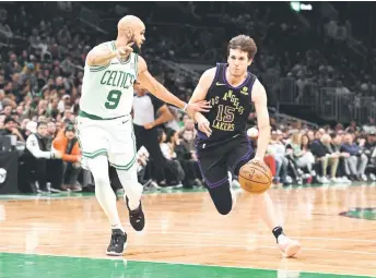  ?? — AFP photo ?? Reaves dribbles the ball against Derrick White of the Boston Celtics.