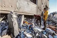  ?? Ahmad Hasaballah/Getty Images ?? People inspect the damage and recover items after Israeli airstrikes on Friday in Rafah, Gaza Strip.