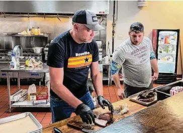  ?? Photos by J.C. Reid/Contributo­r ?? Reveille Barbecue Co. 0wner/pitmaster Michael Michna, left, and assistant Wyatt Norton prepare an order.