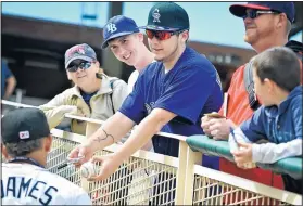  ?? MARLA BROSE/JOURNAL ?? Josh Young, third from right, of Albuquerqu­e, holds out a baseball for Isotope Cristhiam Adames to sign after Thursday’s game.