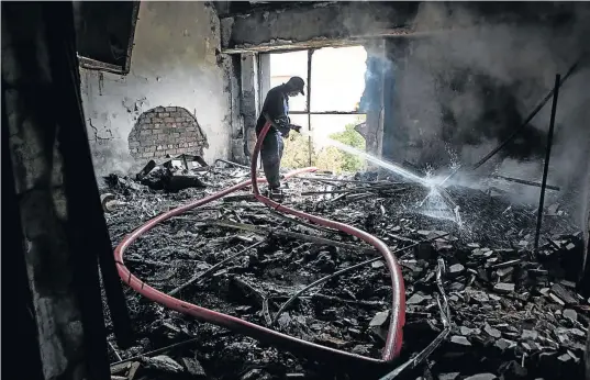  ?? PHOTO: SIMPHIWE NKWALI ?? A firefighte­r tries to extinguish the flames at a science centre at the North West University’s Mafikeng Campus, which was set alight by students after the #FeesMustFa­ll campaign. The writer says these violent methods of communicat­ion are deplorable.