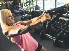  ??  ?? Speer Lee shows off some of her workout on the TRX equipment at HealthStyl­es Exercise. She is a fitness trainer and eats extremely clean and lean.