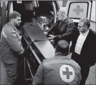  ??  ?? Lebanese Red Cross
AP/BILAL HUSSEIN
workers unload the coffin of British doctor Abbas Khan outside a hospital Saturday in Beirut. Khan was seized by Syrian government troops in November 2012 and died while in detention.