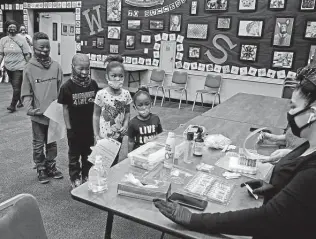  ?? Ronald Cortes / Contributo­r ?? A family lines up to get tested for COVID-19 after spring break. Bexar County commission­ers have committed spending another $2 million for testing by Community Labs.